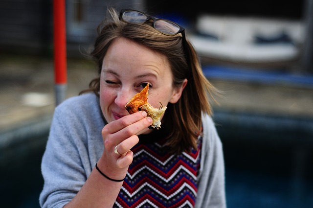 Portrait d'une femme mangeant une pizza